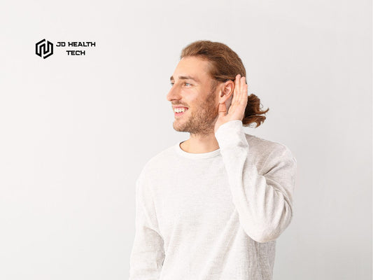A man wearing a hearing amplifier on a plain background