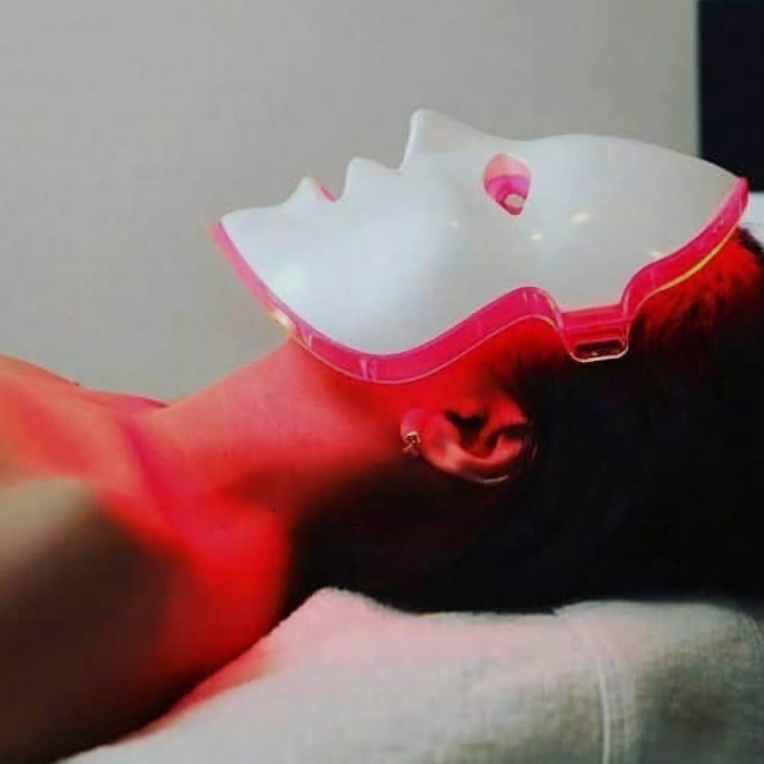 Lady wearing red light therapy mask.