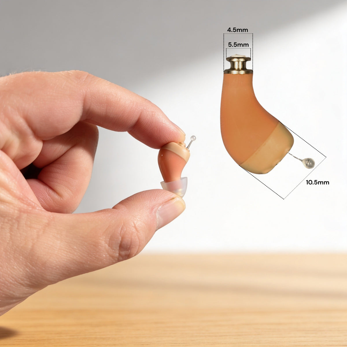 Clarity Pro Micro CIC hearing amplifier held between two fingers, showing its 20 x 9 x 7 mm size