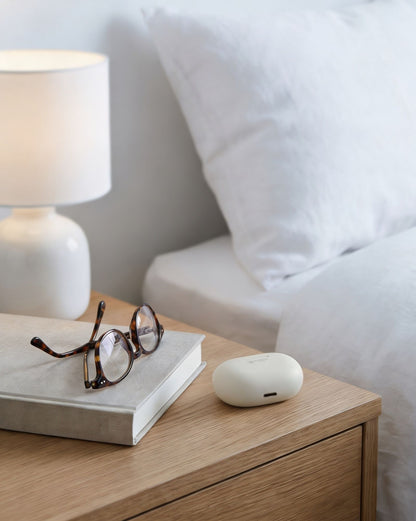 Clarity Pro Micro CIC hearing amplifiers with charging case on bedside table